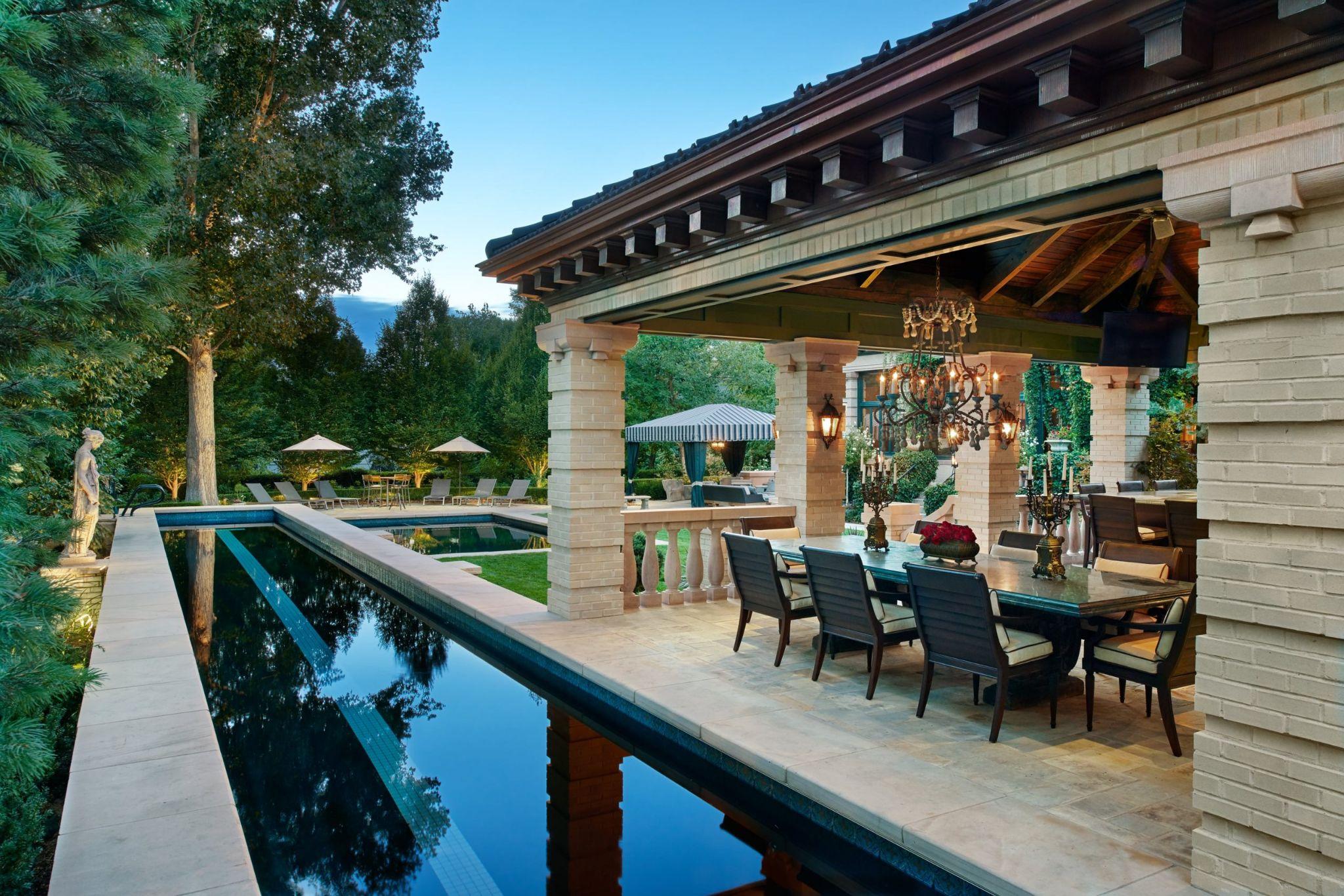 Covered outdoor dining patio beside a reflecting pool
