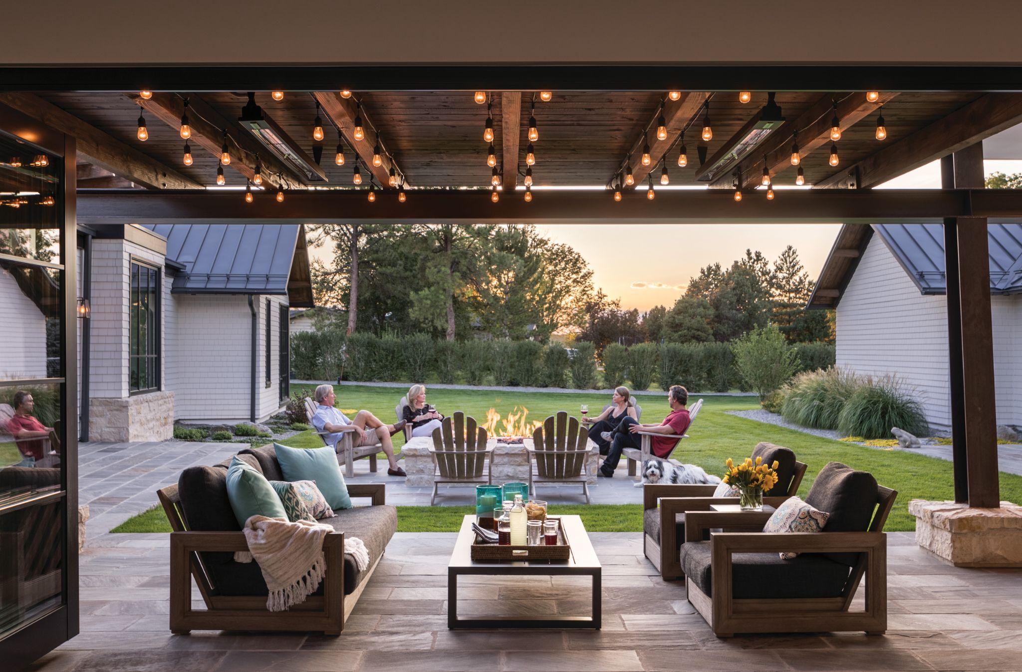 Covered patio lounge with fire pit and string lighting