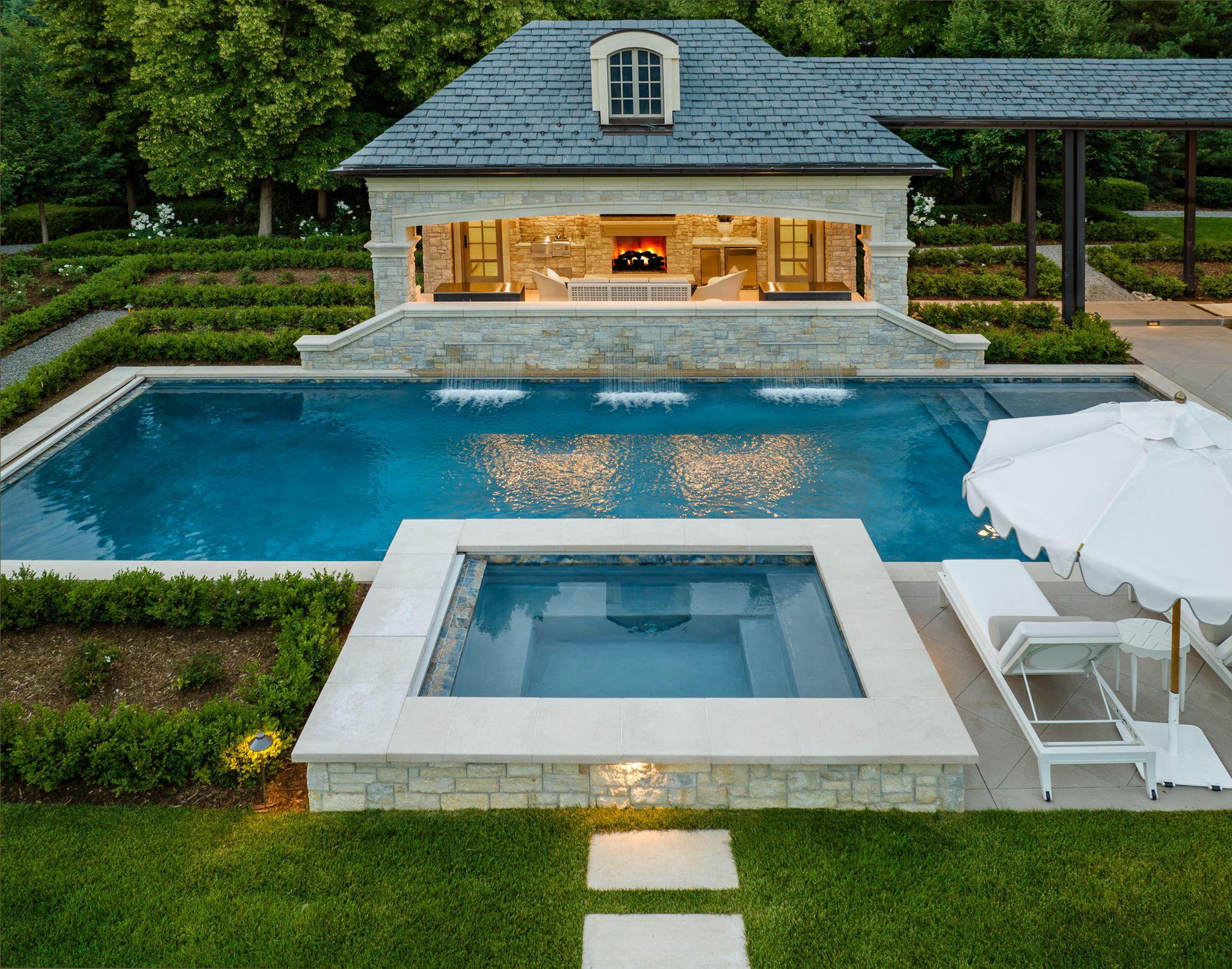 Formal pool and spa with stone pavilion and fireplace
