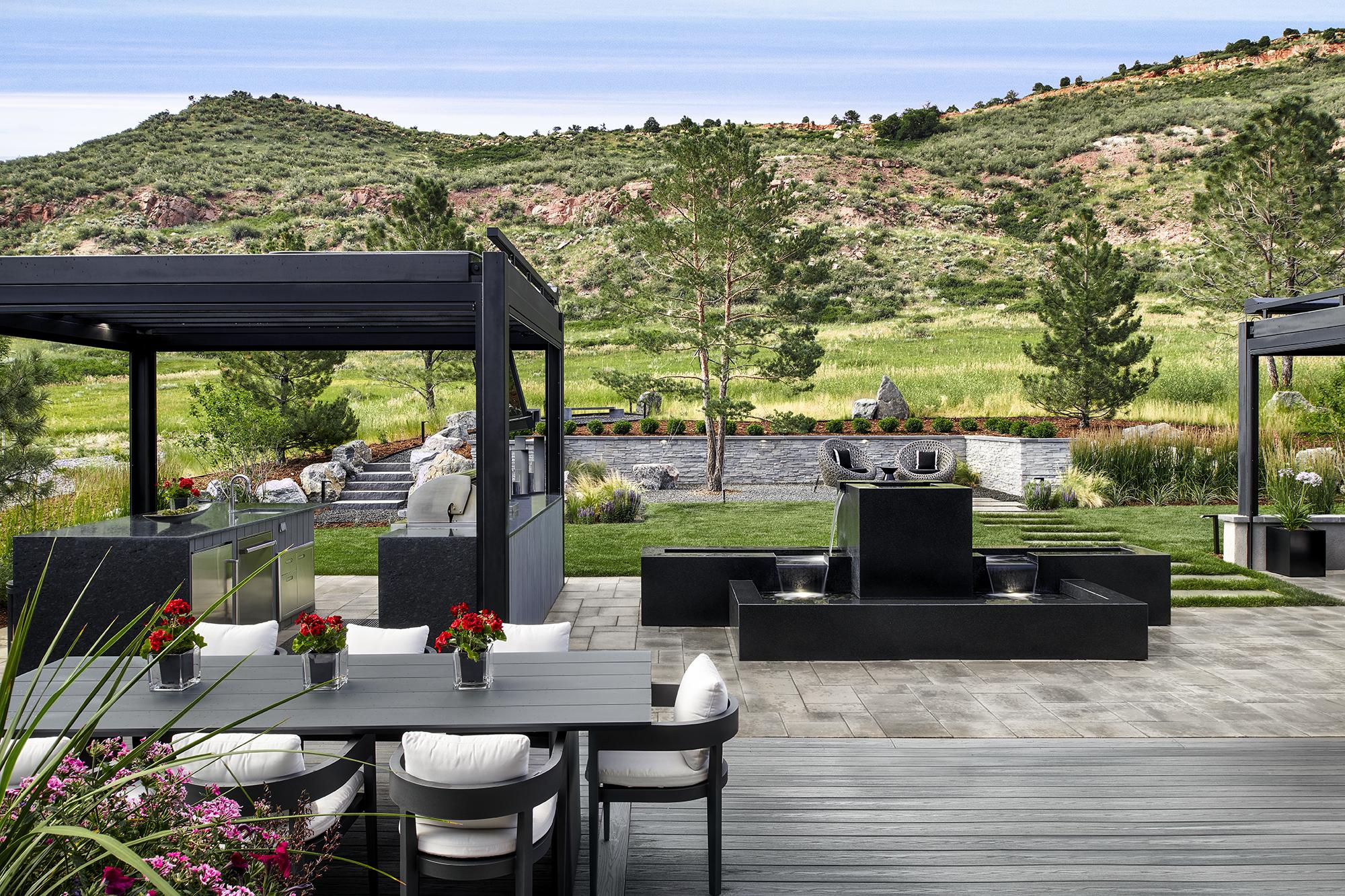 Modern outdoor kitchen and water feature with pergola