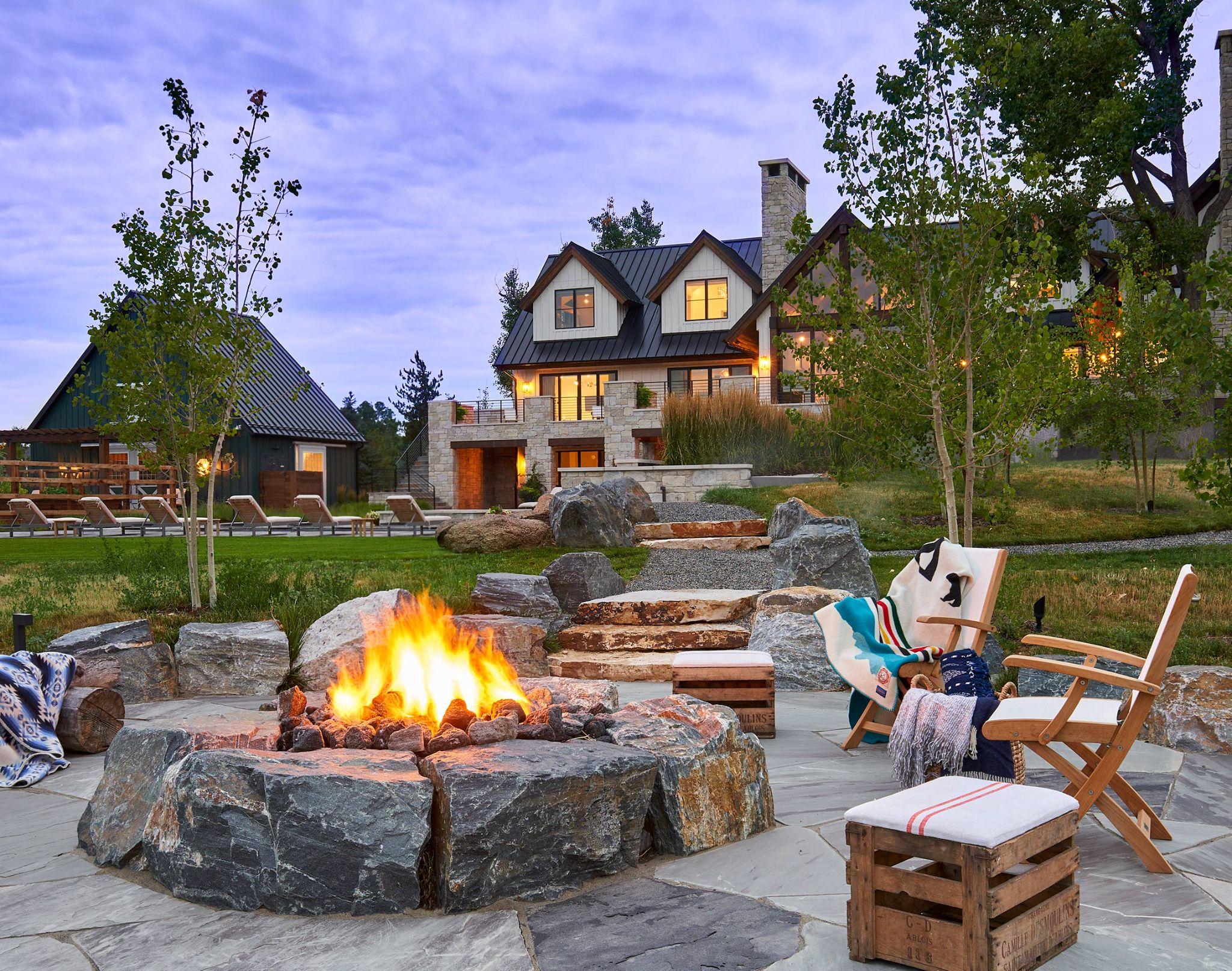 Stone fire pit seating area in mountain-style landscape