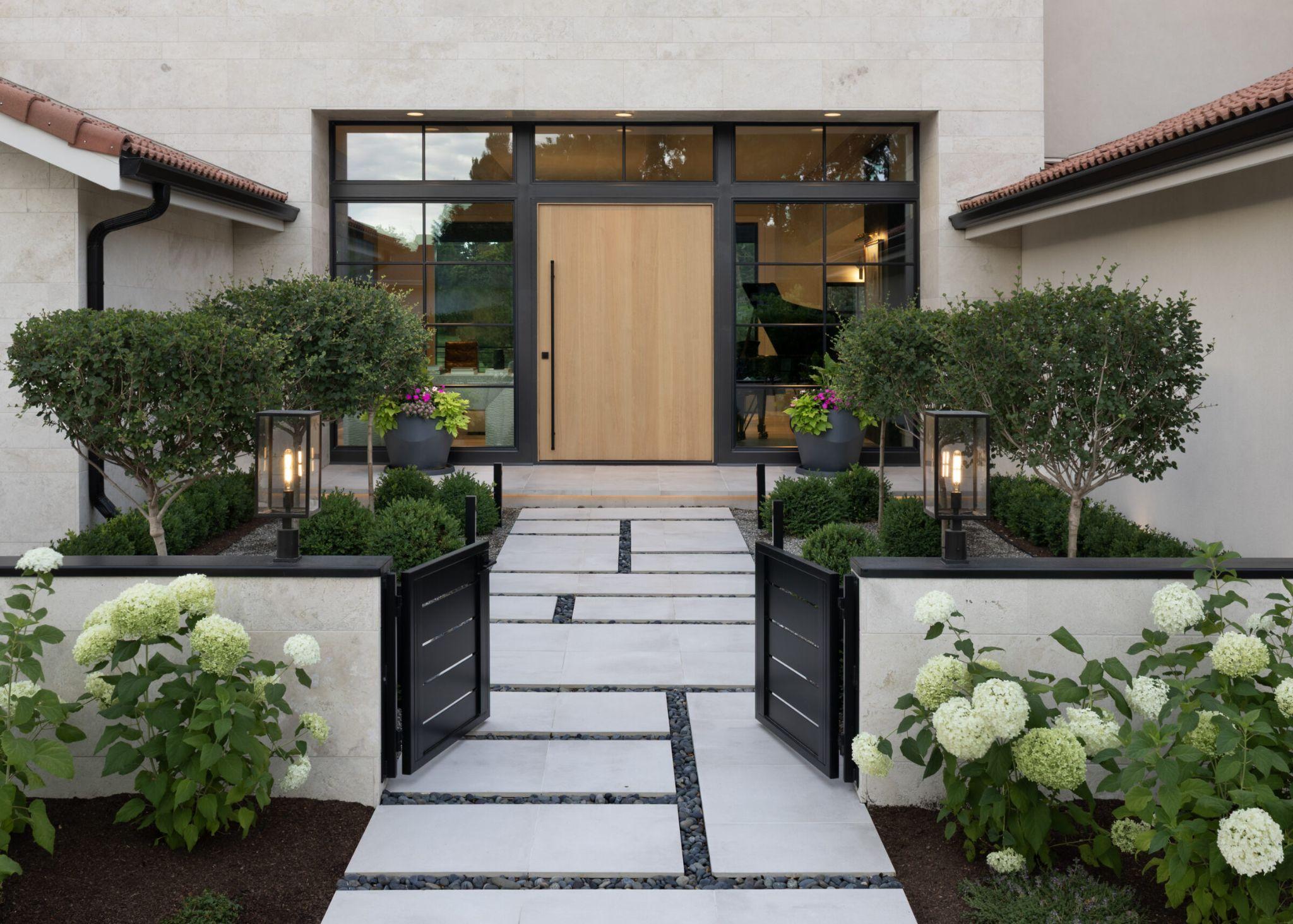 Modern front entry walkway with hydrangeas and lantern lights